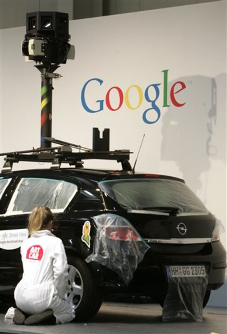 In this March 2, 2010 file photo, a woman decorates a camera car of Google at the CeBIT in Hannover, northern Germany. British authorities say Google breached data protection laws when its Street View mapping service scooped up data from private wireless networks. 